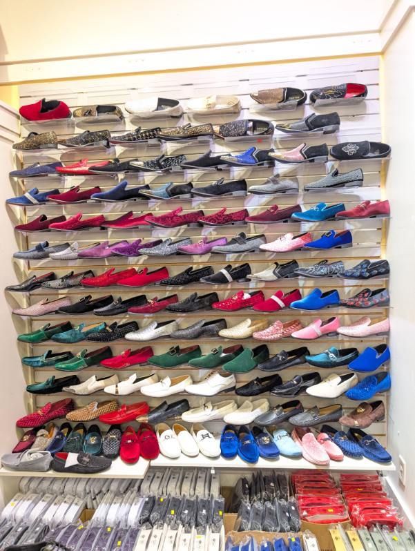 Shoes displayed on shelves in a retail store, various colors and styles.