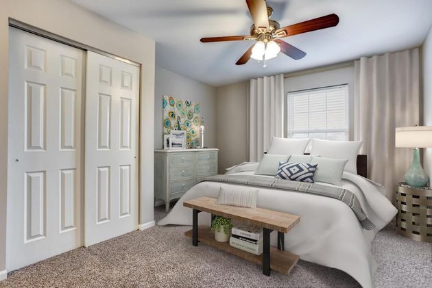 a bedroom with a ceiling fan and a bed .
