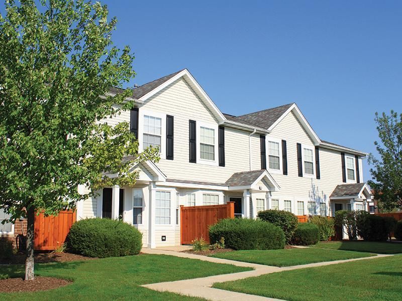 a row of white houses with black shutters on the windows