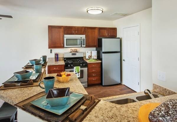 a kitchen with a stainless steel refrigerator , stove , microwave and sink .