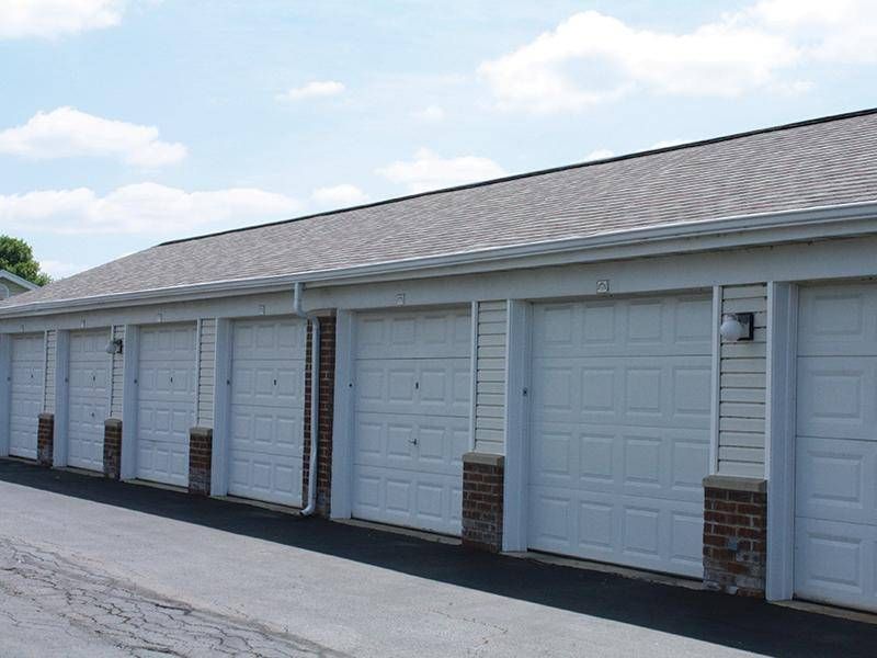 a row of white garage doors are lined up next to each other .