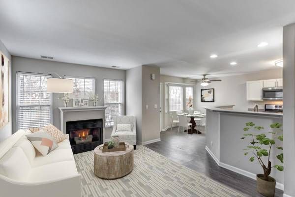 a living room with a couch , chair , table and fireplace .