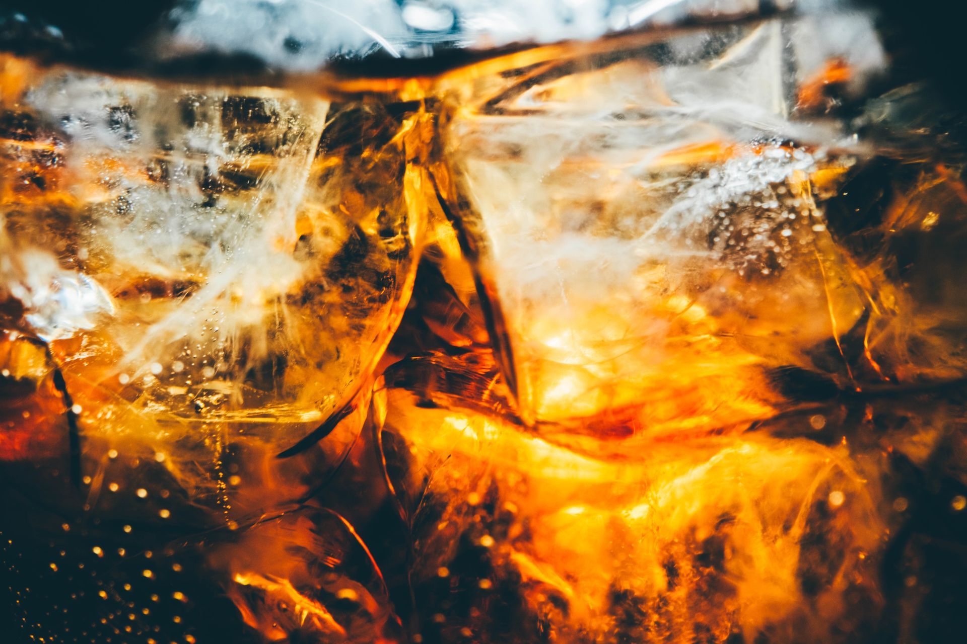 A glass of cold cola with ice cubes.