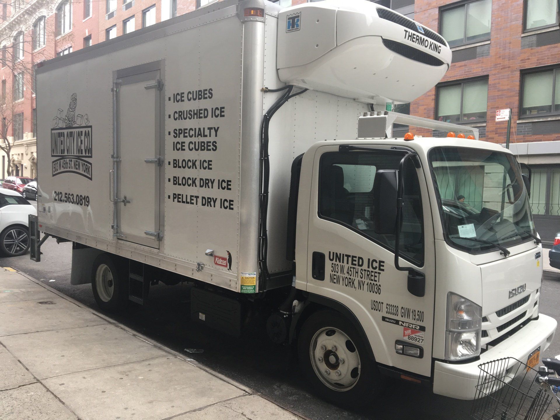 A white truck is parked on the side of the road.