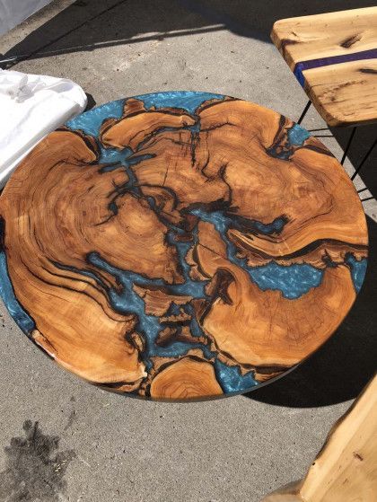 A round wooden table with a blue resin top