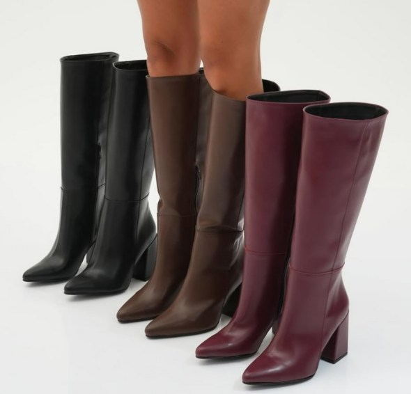 Una mujer que lleva una hilera de botas hasta la rodilla de diferentes colores.