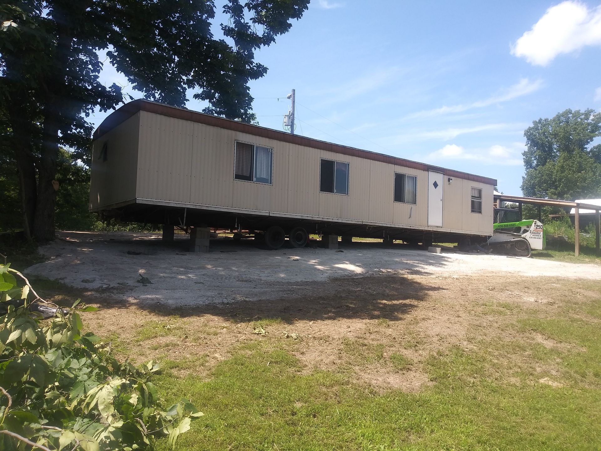 A Mobile Home Is Sitting in The Middle of A Grassy Field | Winfield, MO | Excalibur Manufactured Housing Services LLC