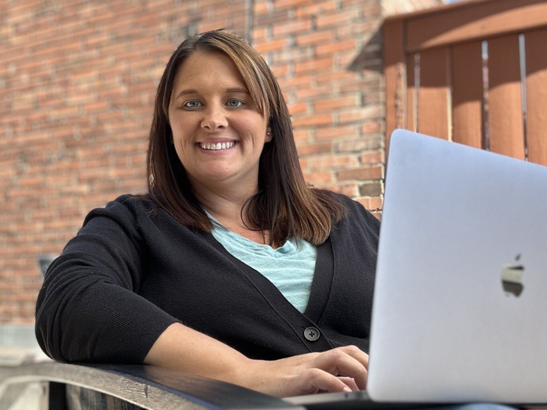 A woman is sitting at a table with a laptop computer.