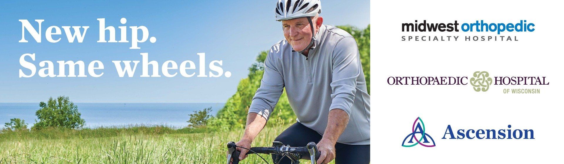 A man wearing a helmet is riding a bike in a field.