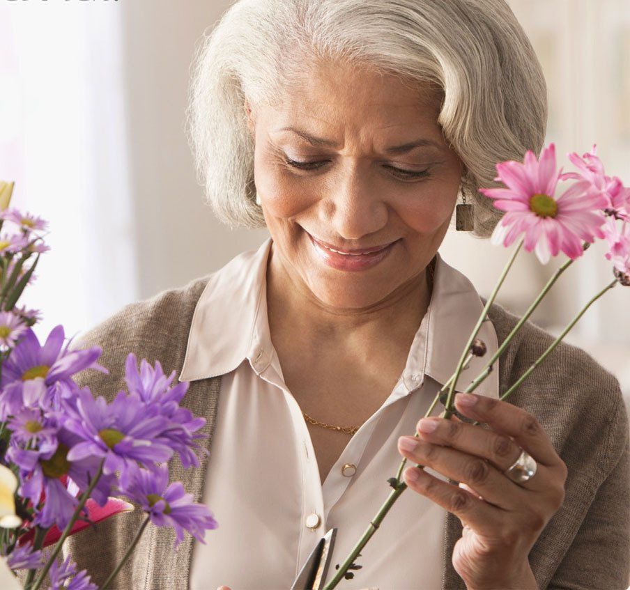 A woman is holding purple and pink flowers in her hands