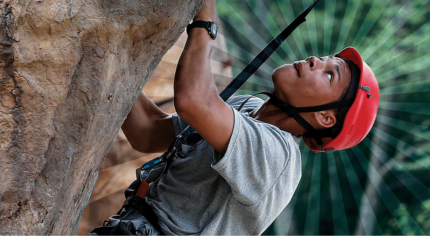 A man wearing a red helmet is climbing a rock wall