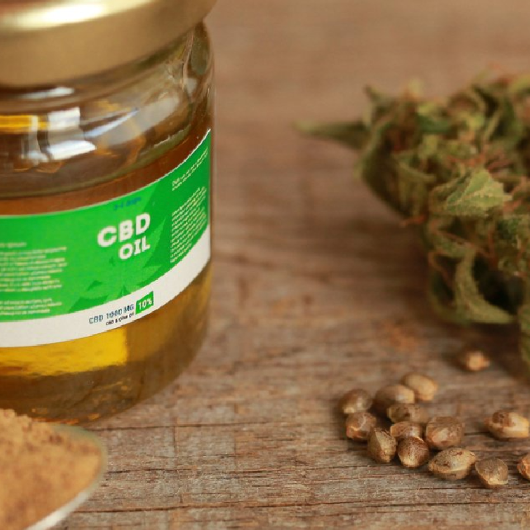 A jar of cbd oil is sitting on a wooden table.