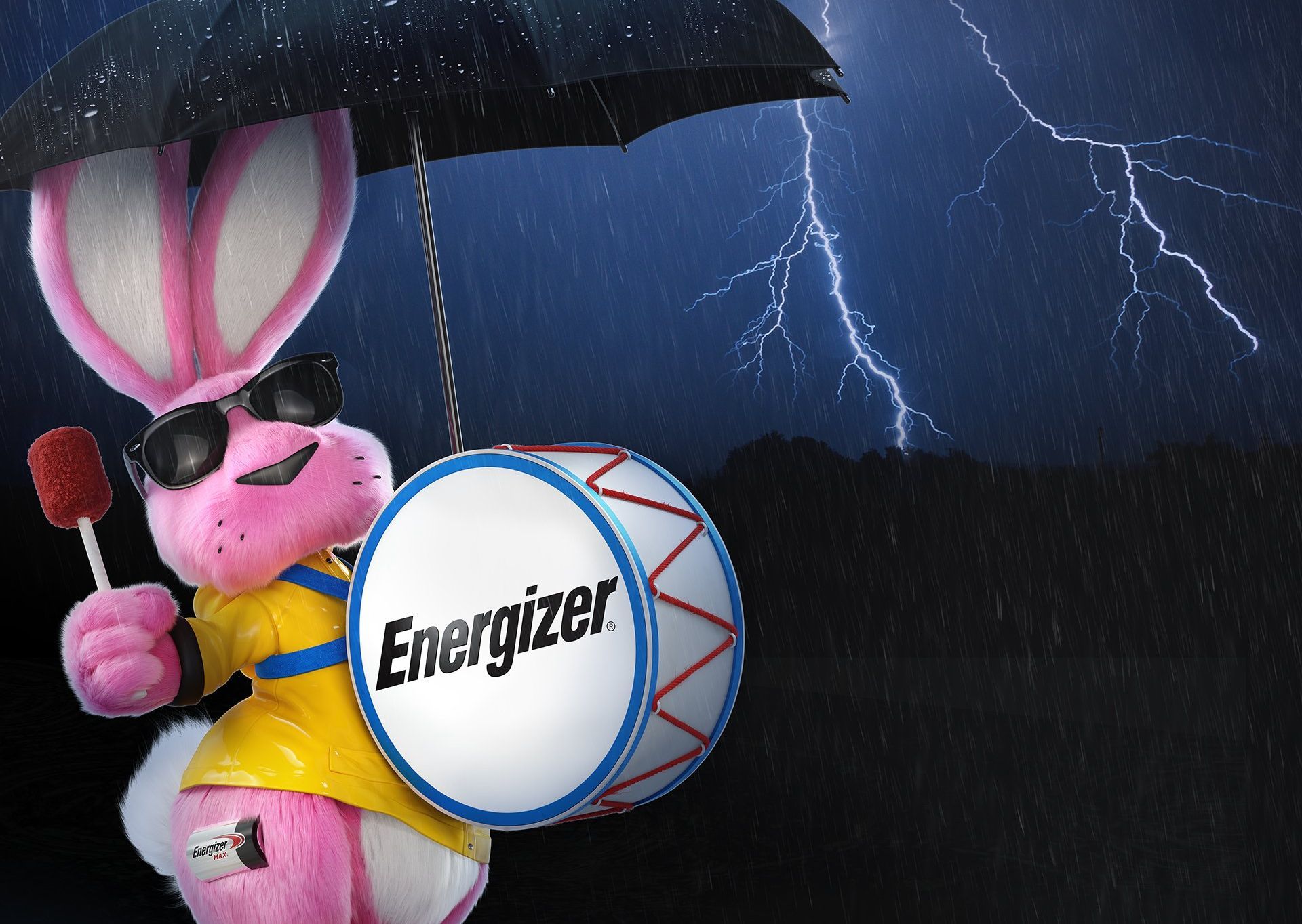 A pink energizer bunny holding an umbrella and a drum