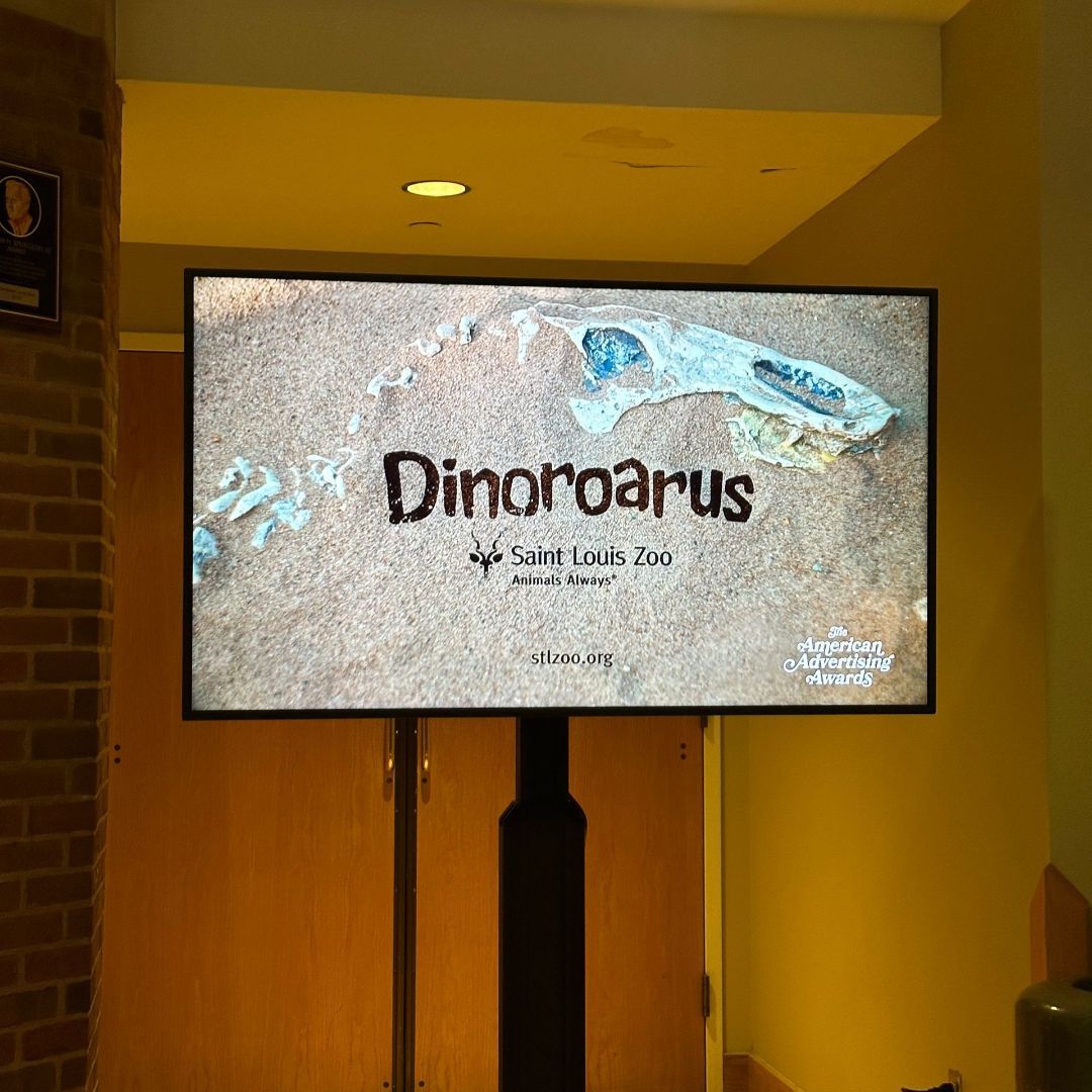 A large screen displays a picture of a dinosaur skull and says dinosaurus