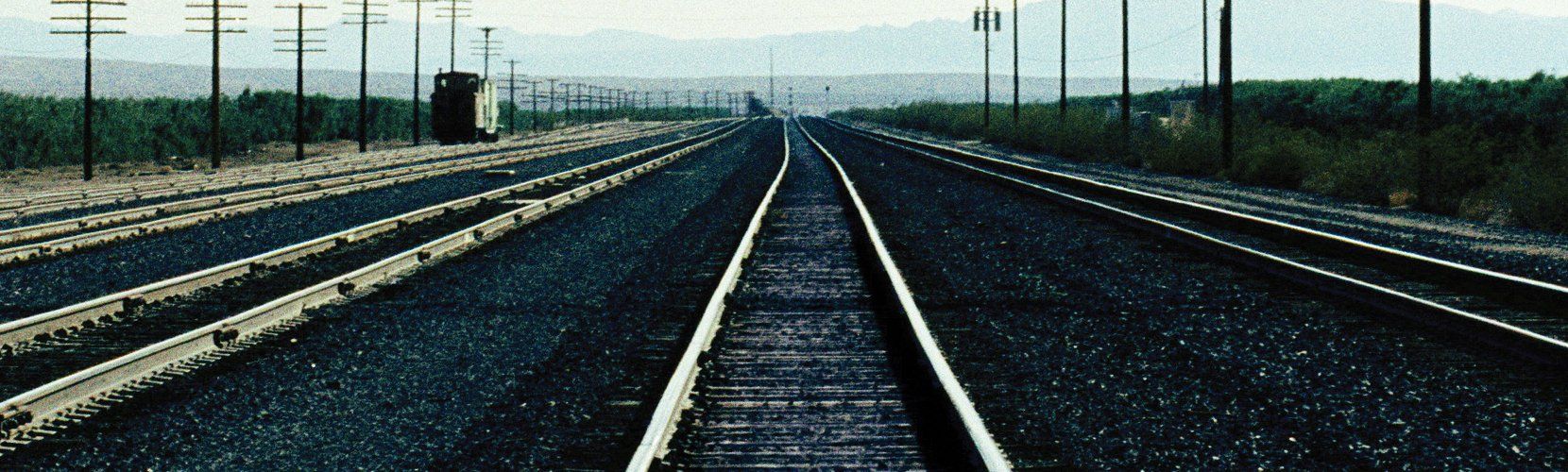 A train track with a lot of power lines in the background