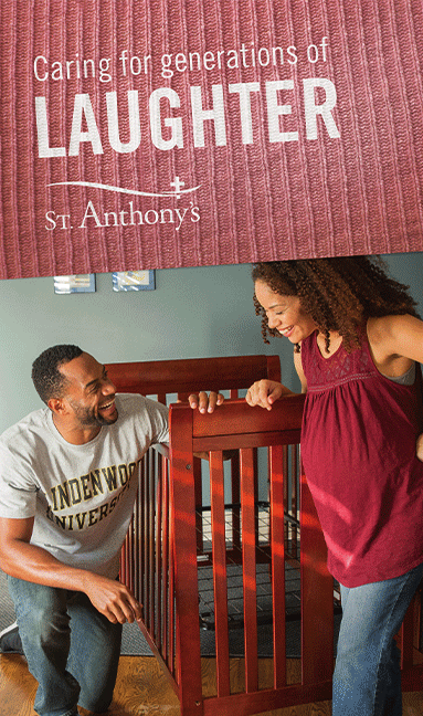 A man and a woman are standing next to a crib.