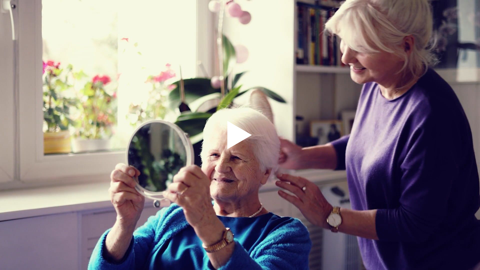 A hairdresser styling a resident's hair