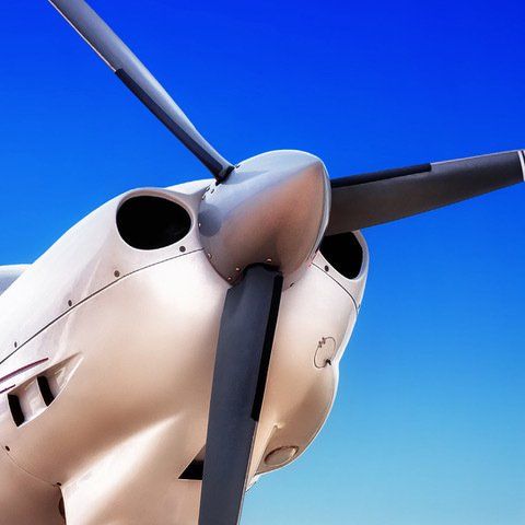 A close up of an airplane propeller against a blue sky