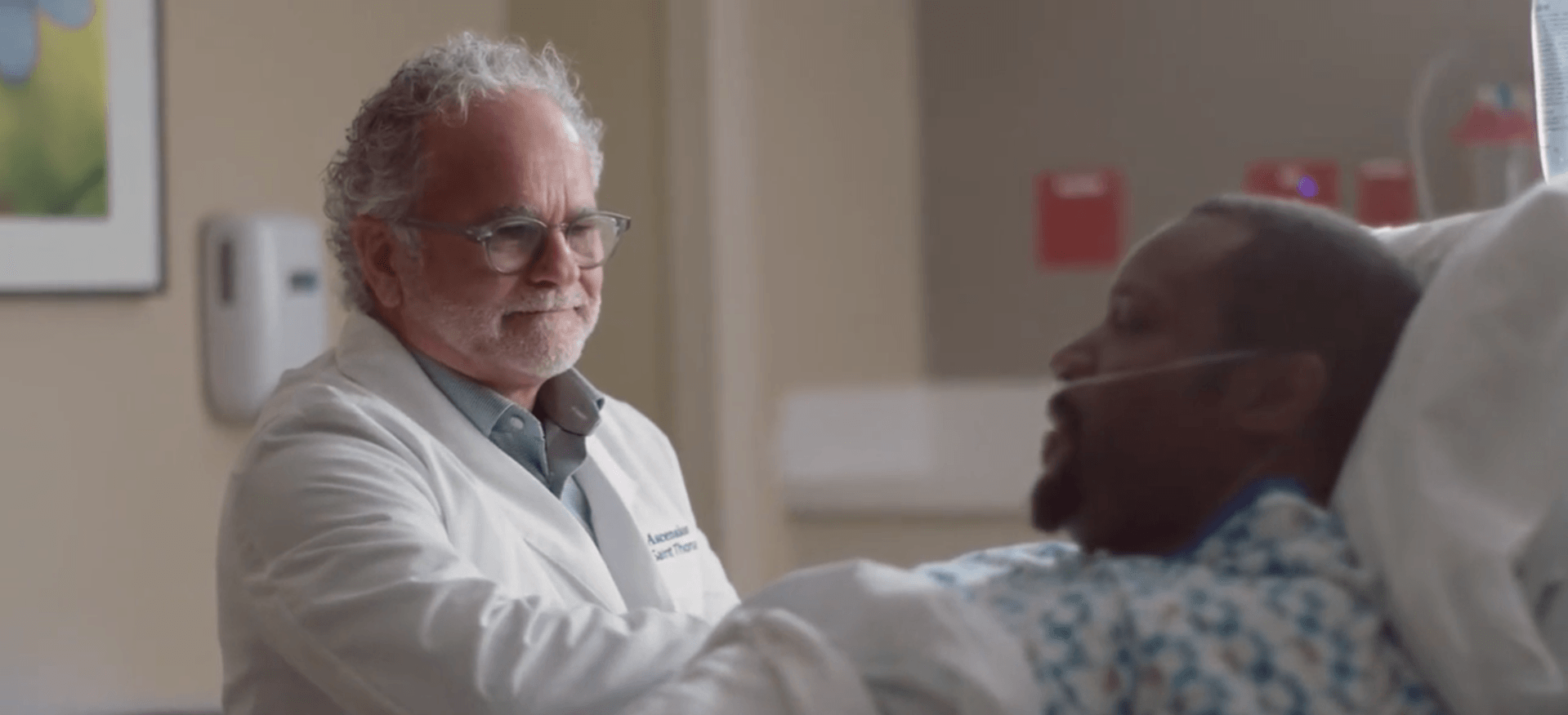 A doctor is talking to a patient in a hospital bed.