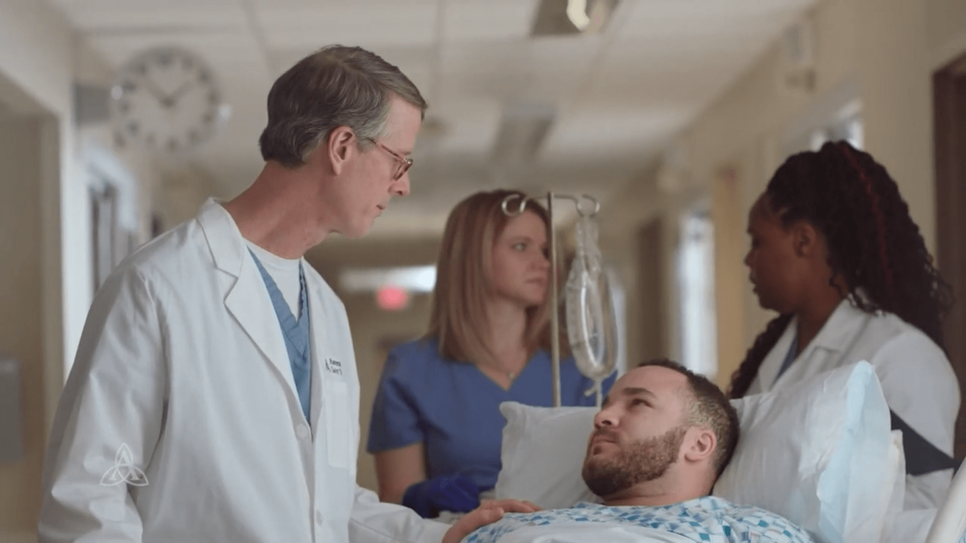 A doctor is talking to a patient in a hospital bed.
