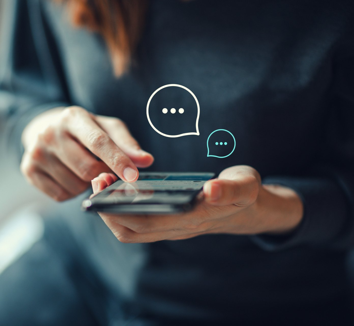 A woman is holding a cell phone with speech bubbles coming out of it.