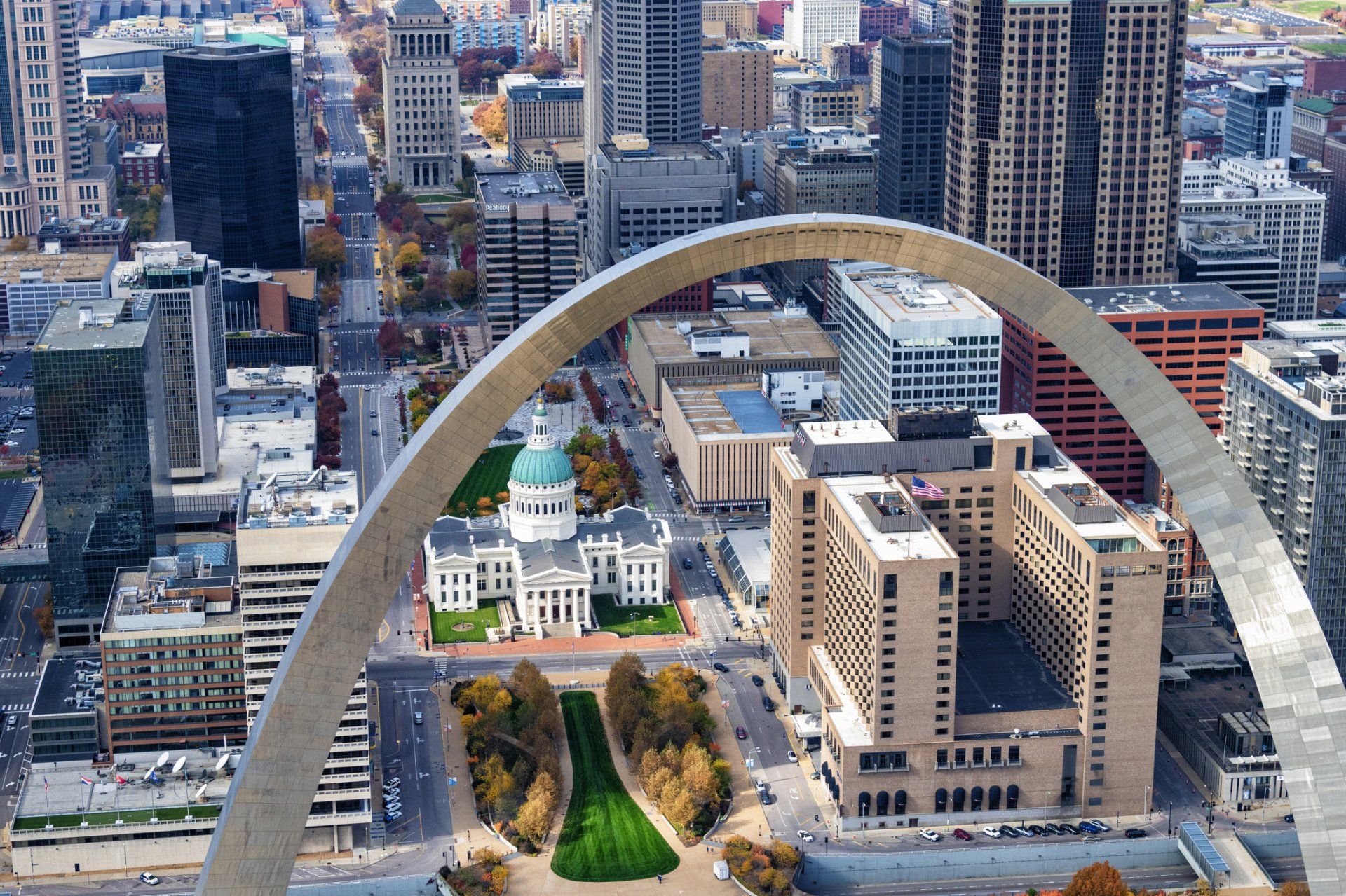 An aerial view of a city with a large arch in the middle.