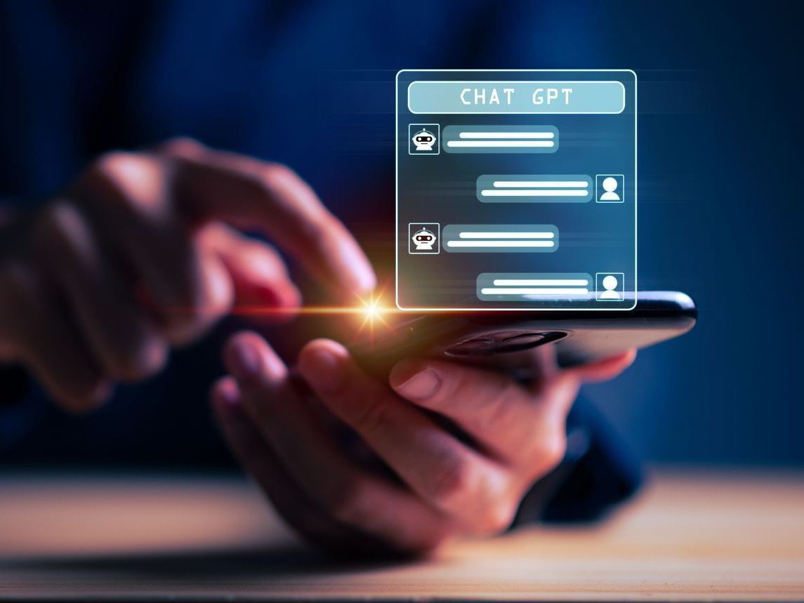 A person is holding a smart phone with a chat app on it.