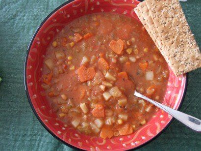 A bowl of soup with crackers and a spoon in it