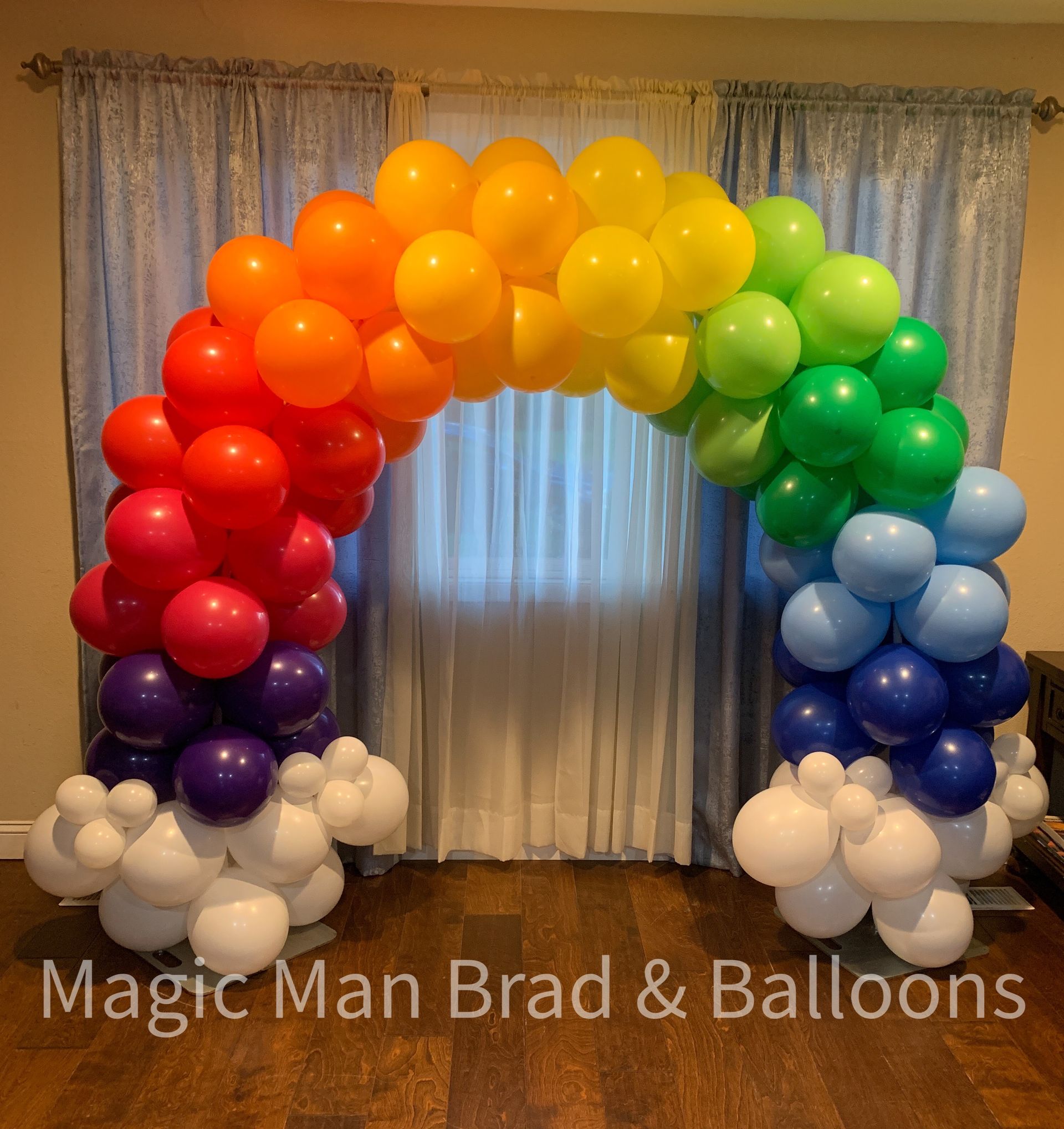 A room with a rainbow arch made of balloons by magic man brad & balloons