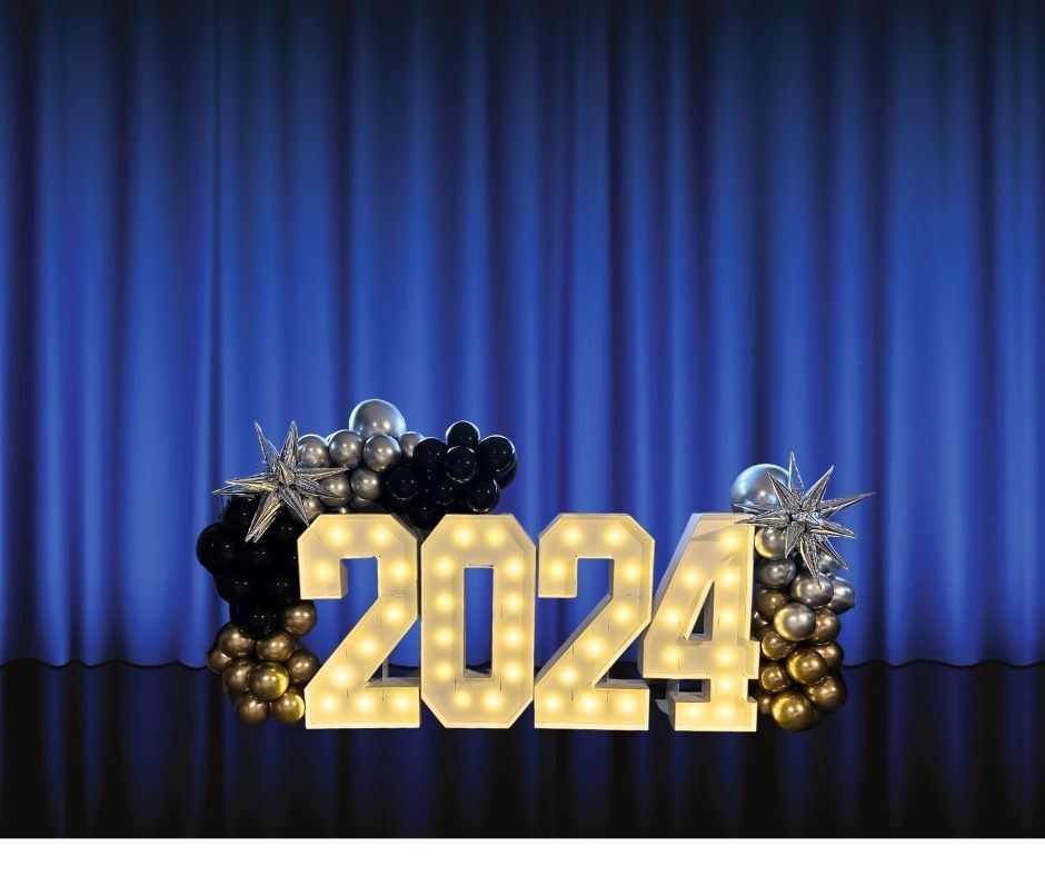 A stage with a blue curtain and a sign that says 2024