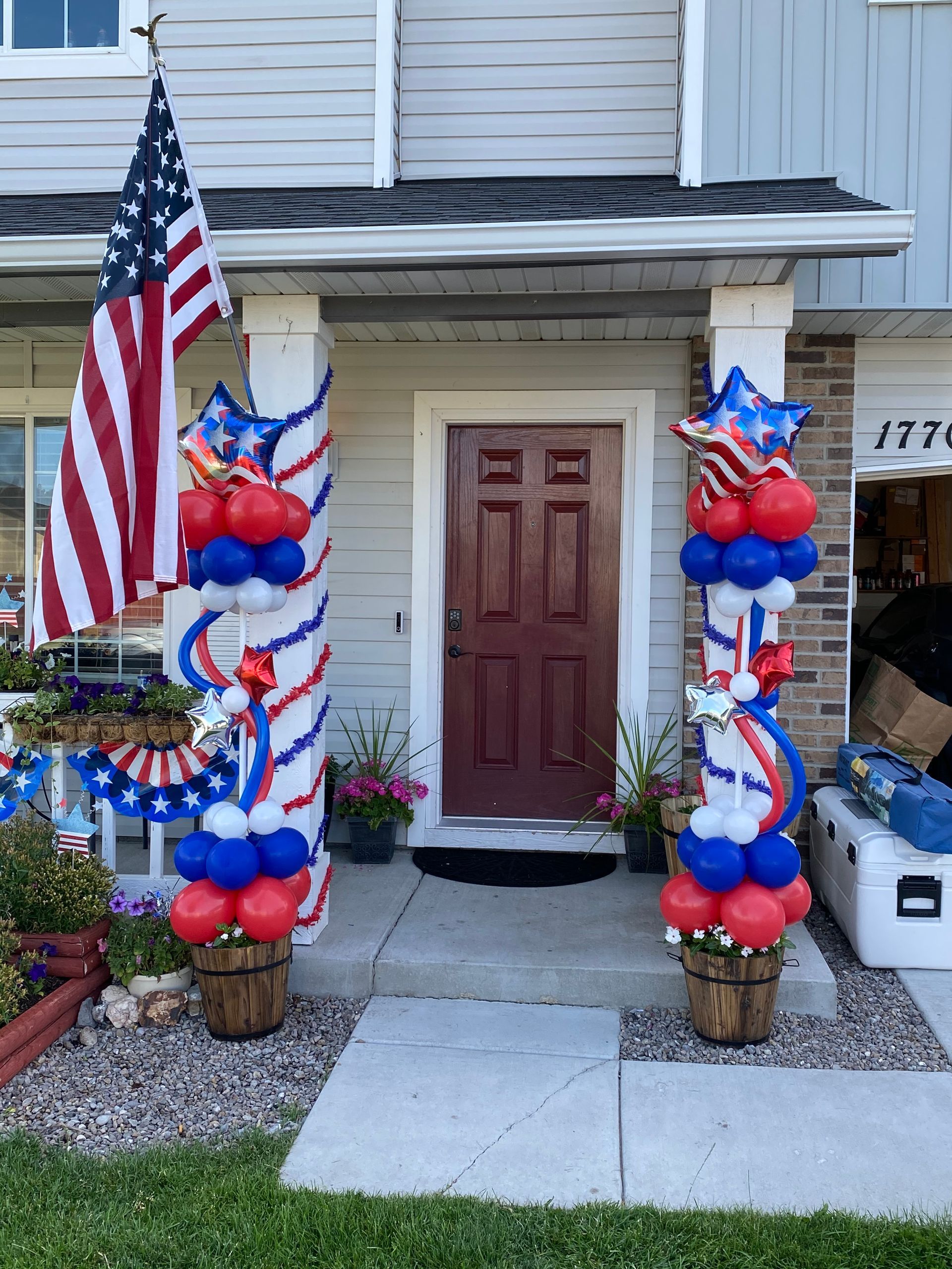 A house is decorated for the fourth of july with balloons and flags.