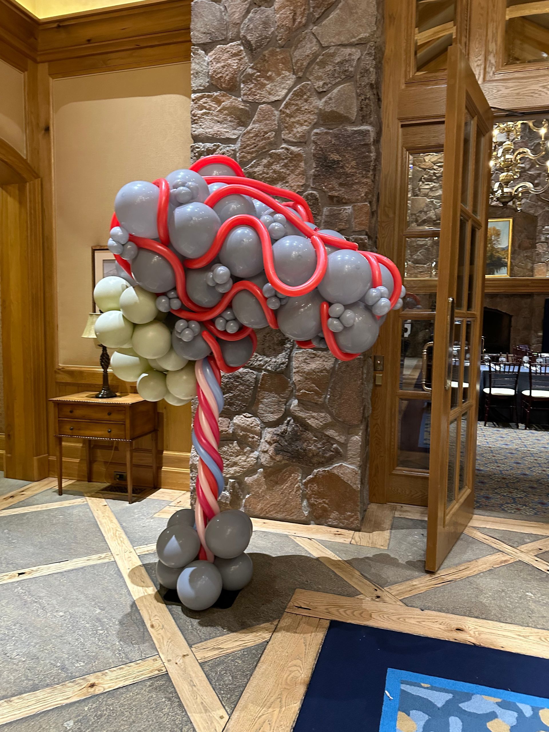 A candy cane made out of balloons in a room.