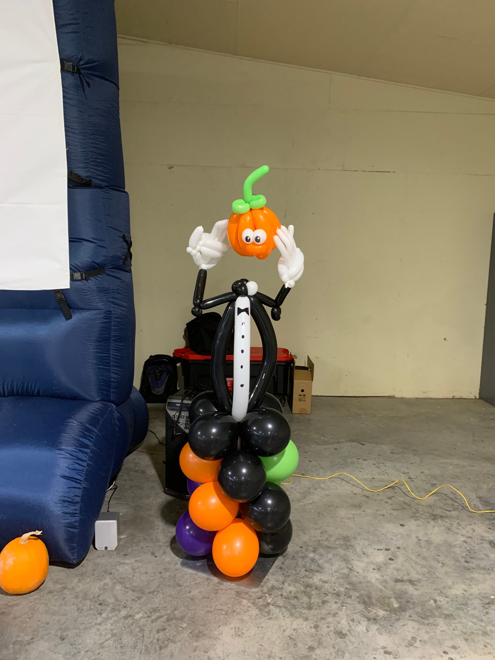 A pumpkin made out of balloons is sitting on top of a pile of balloons.