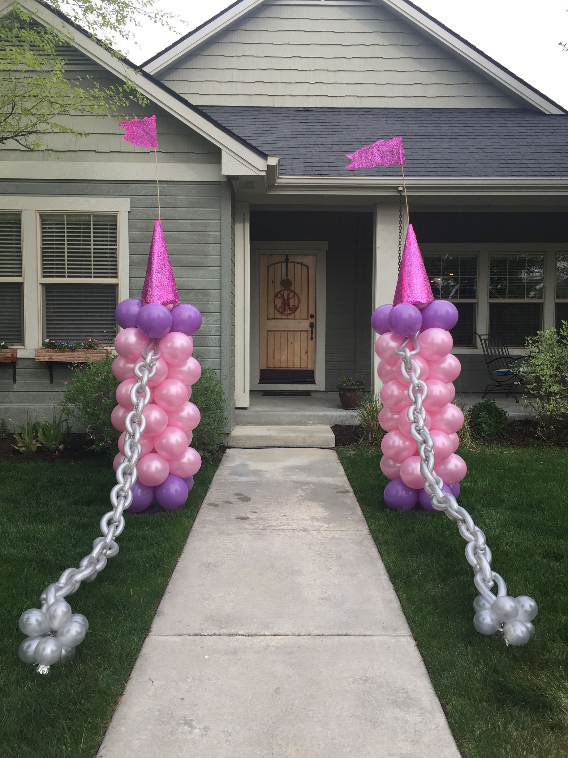 A house decorated with pink and purple balloons and chains