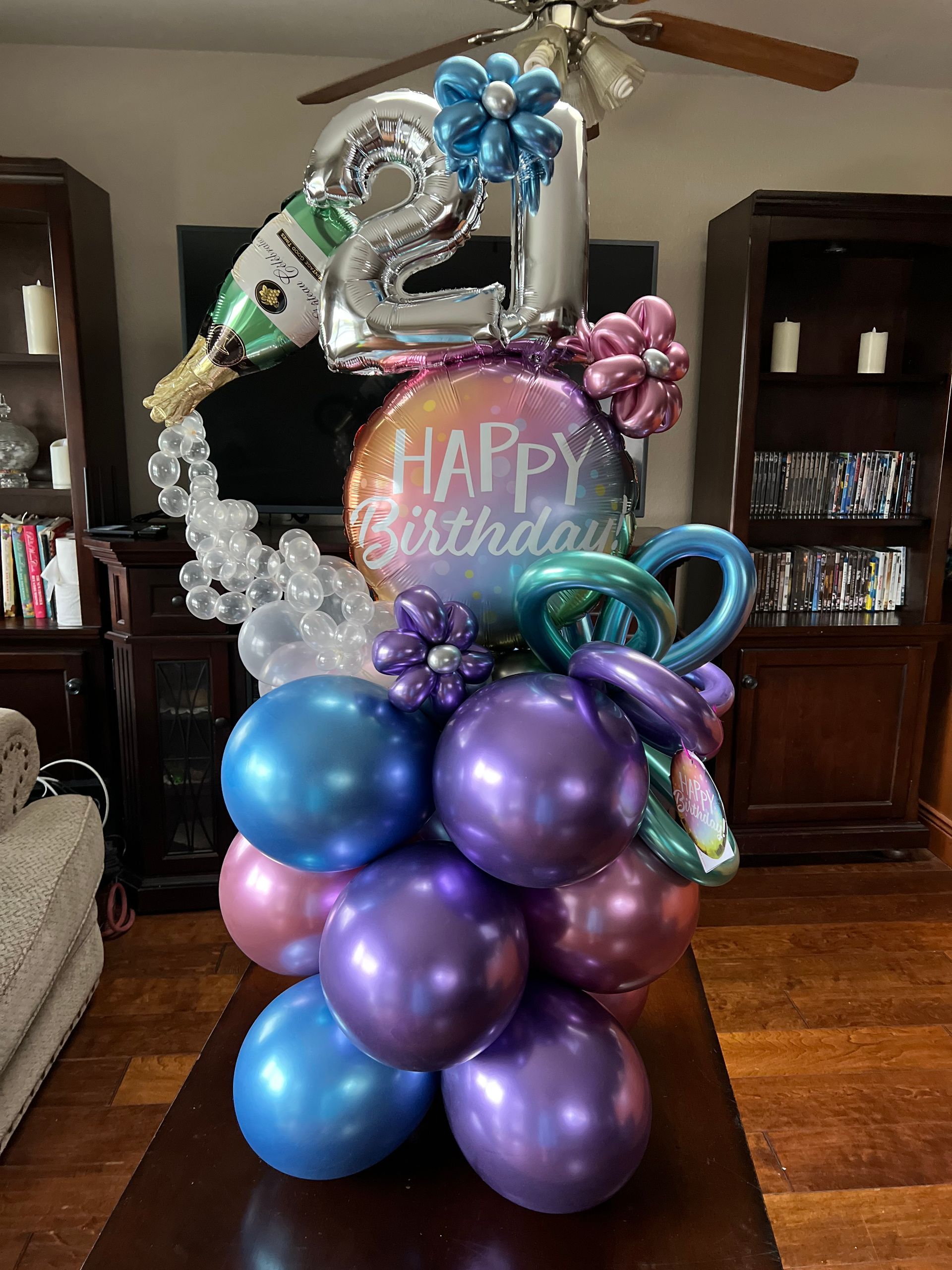A bunch of balloons are sitting on a table in a living room.