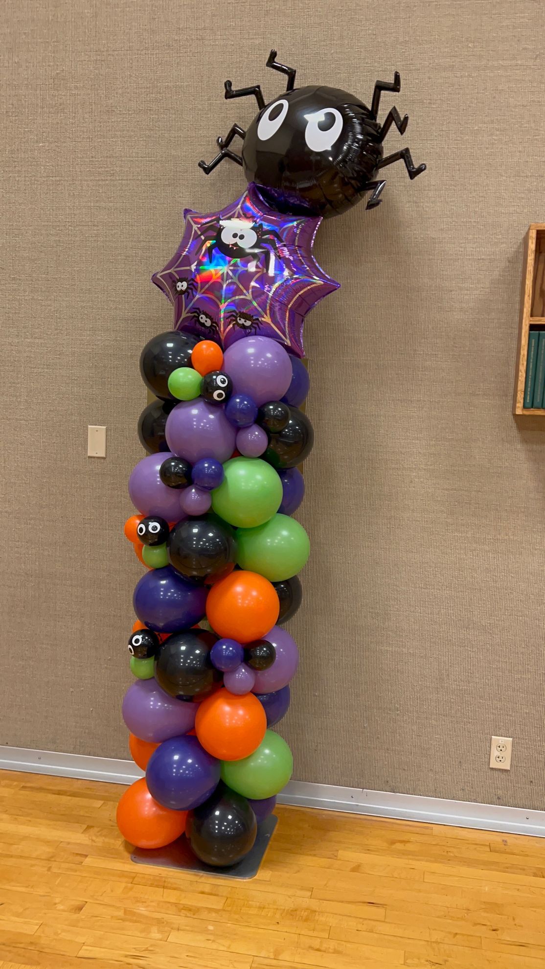 A balloon tower with a spider on top of it.
