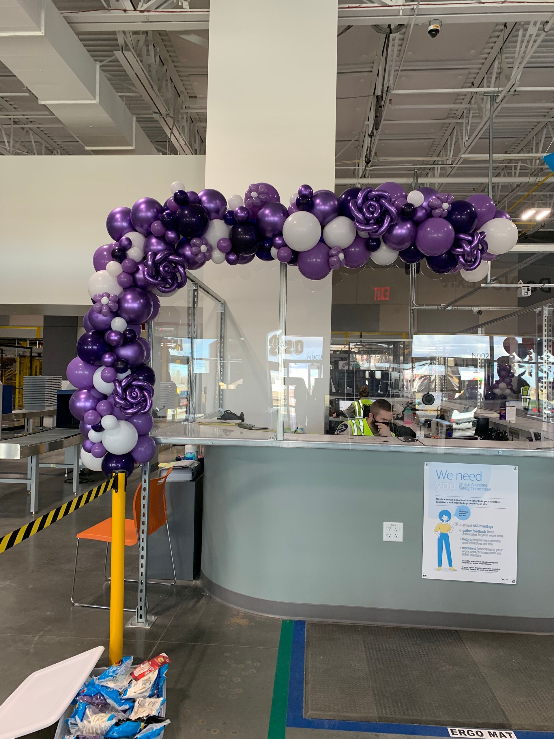 A purple and white balloon arch in a store