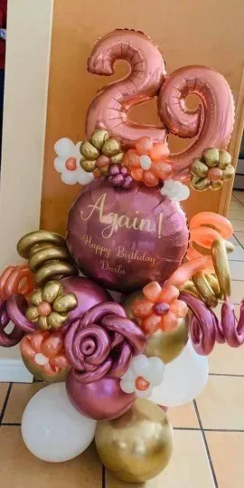 A bunch of balloons are sitting on a tiled floor.