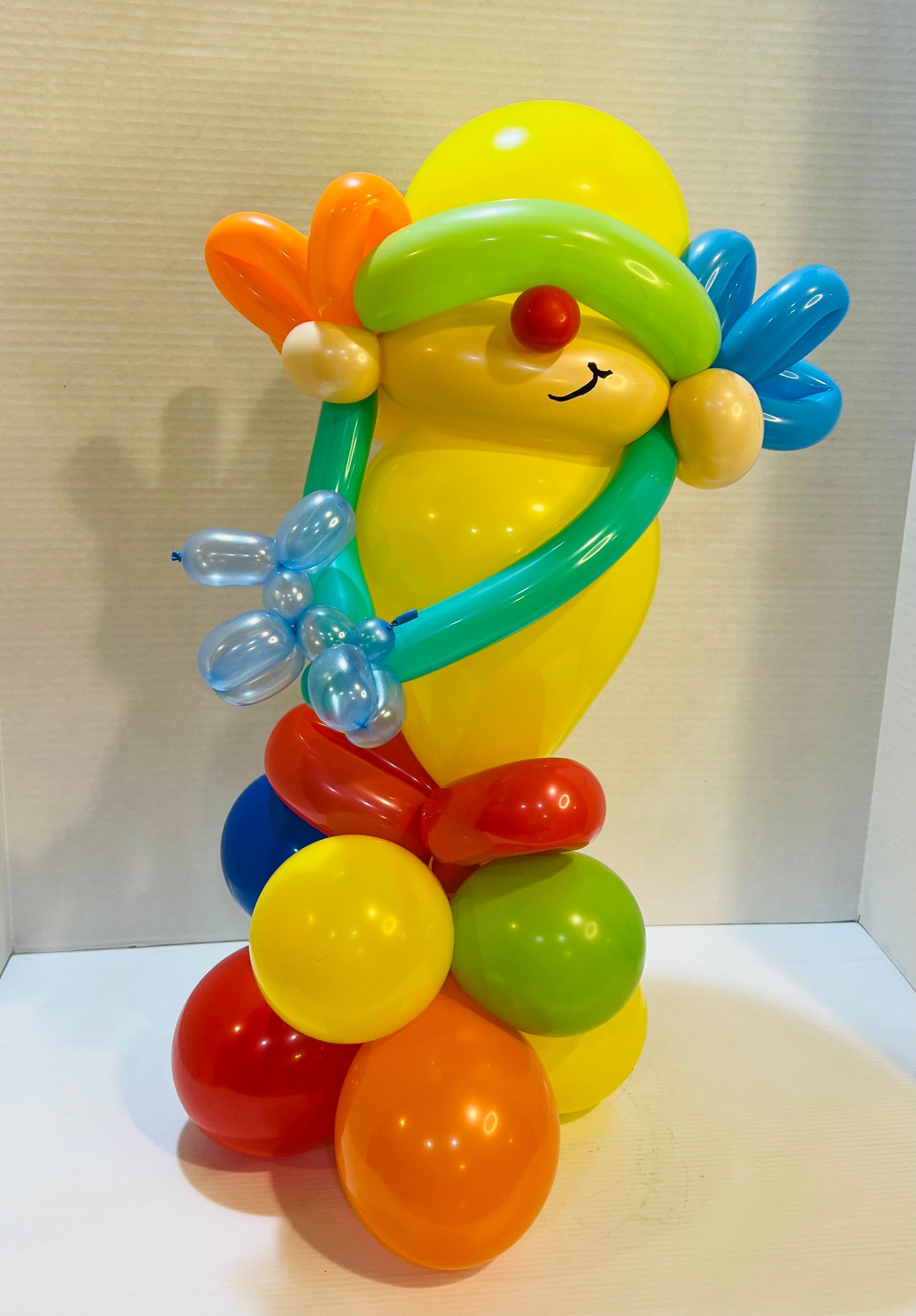 A clown made out of balloons is sitting on a table