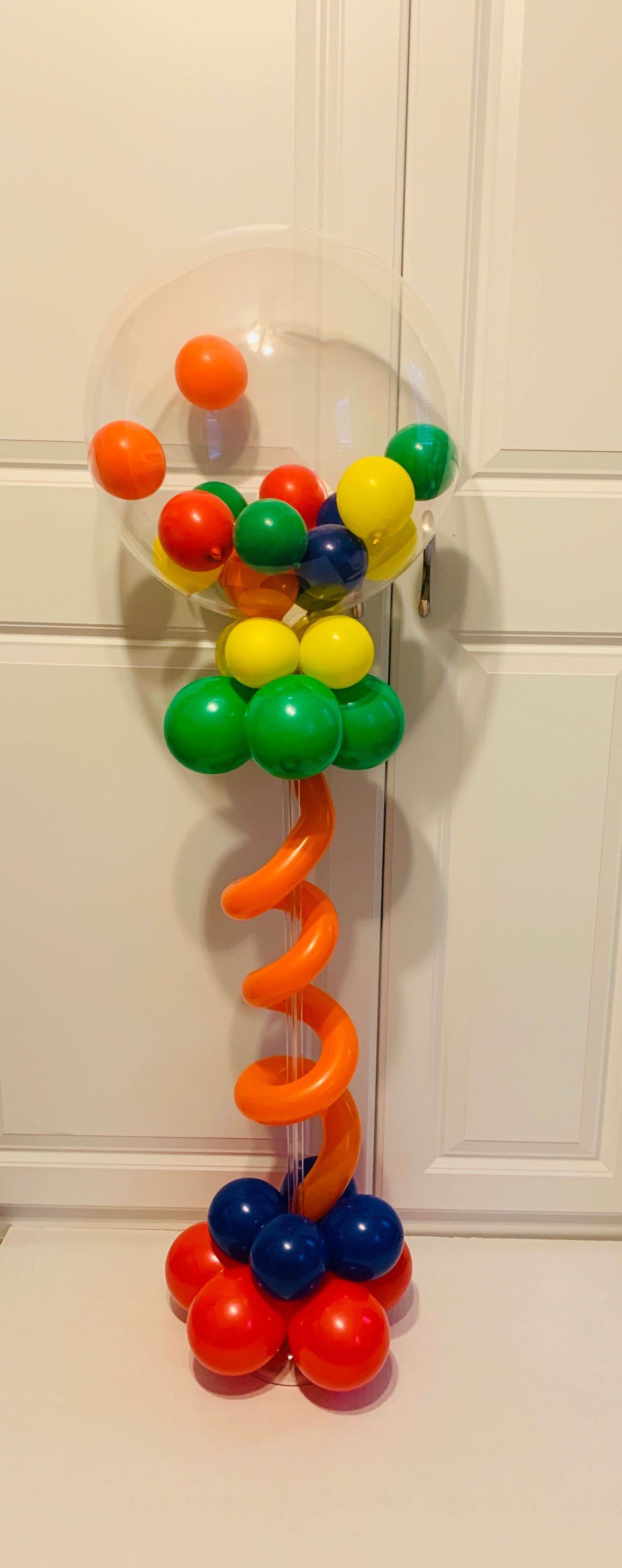 A vase filled with colorful balloons is sitting on a table.