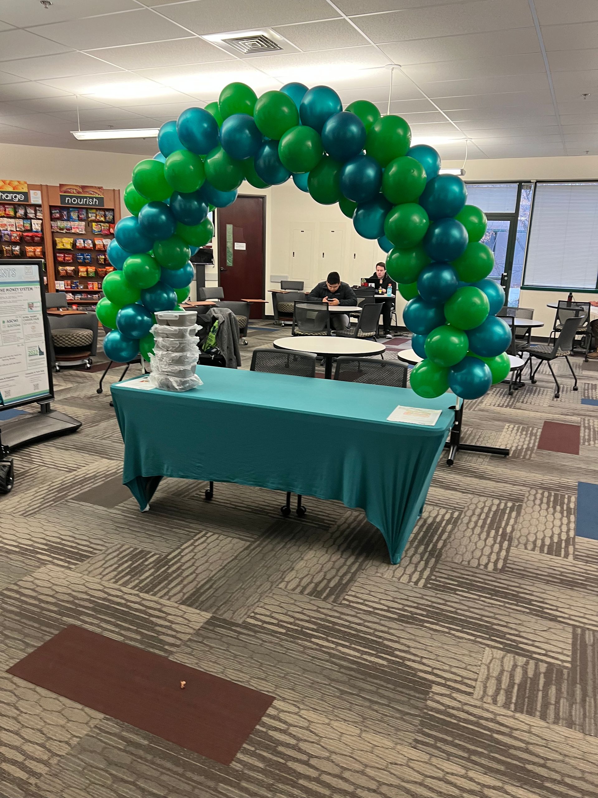 A room with a table and a balloon arch in it.