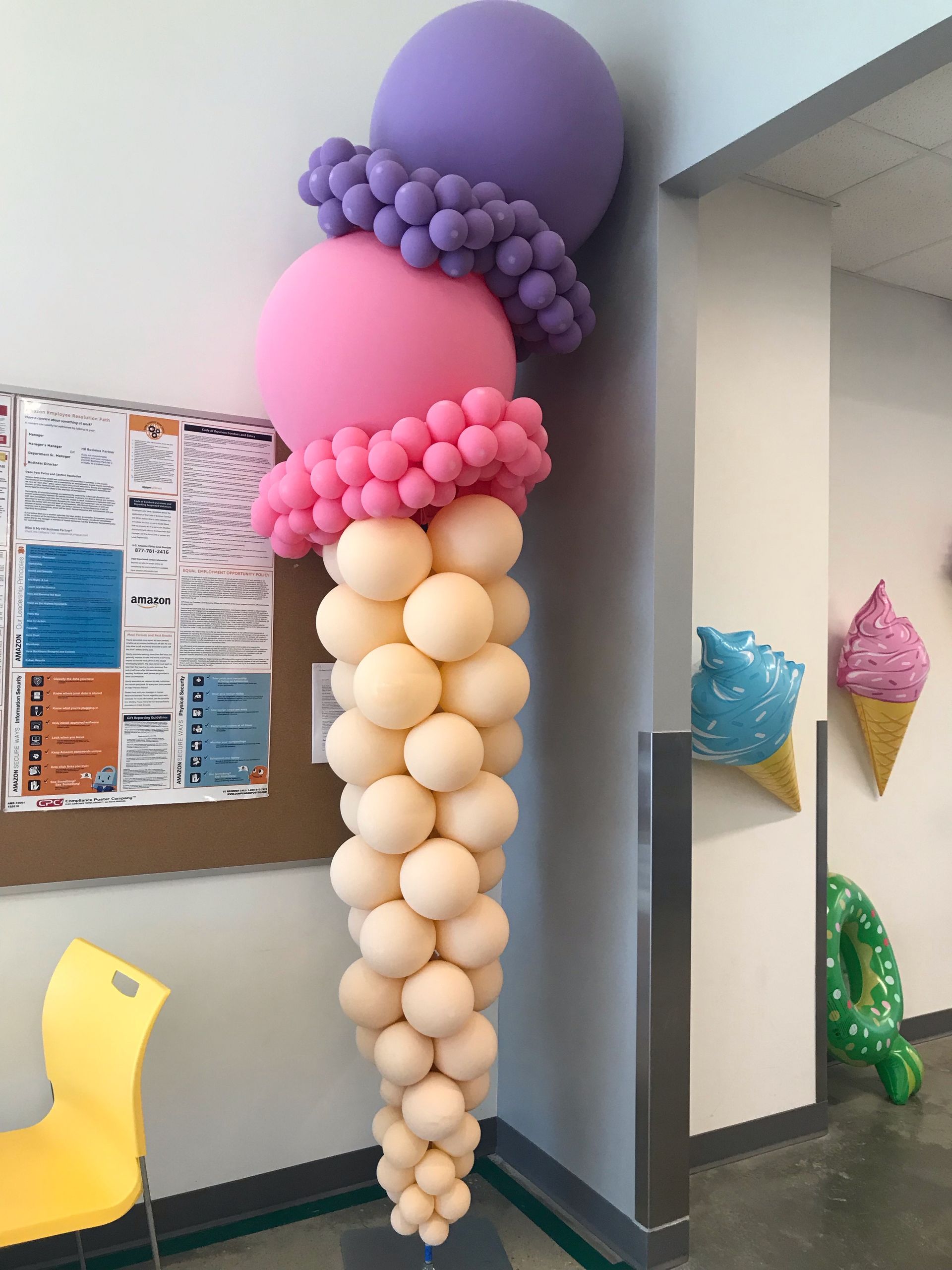 An ice cream cone made of balloons in a room