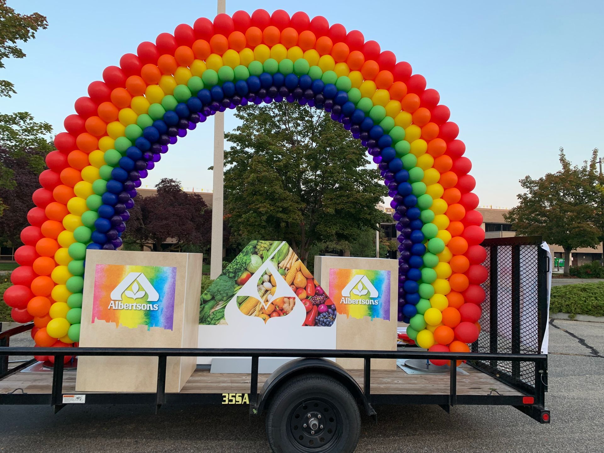 A trailer with a rainbow of balloons on it