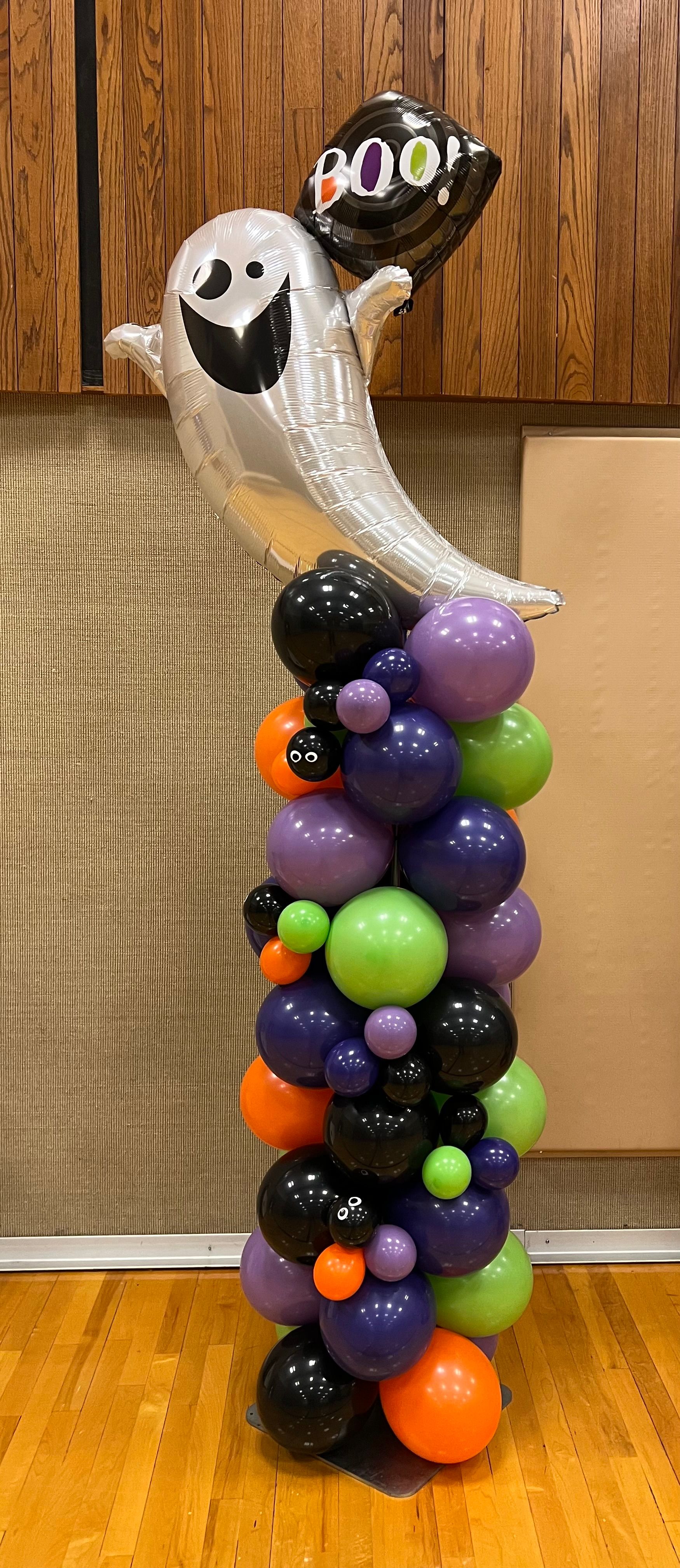 A ghost balloon is sitting on top of a balloon tower.