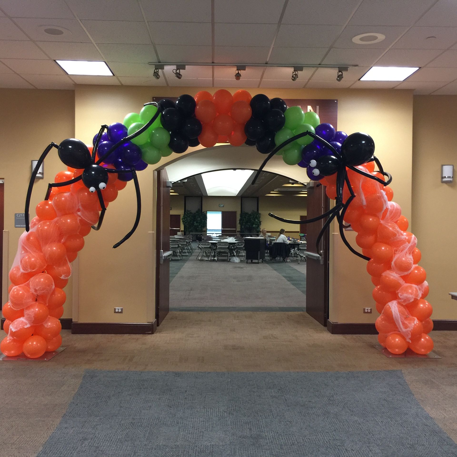 A large arch made of balloons with spiders on it