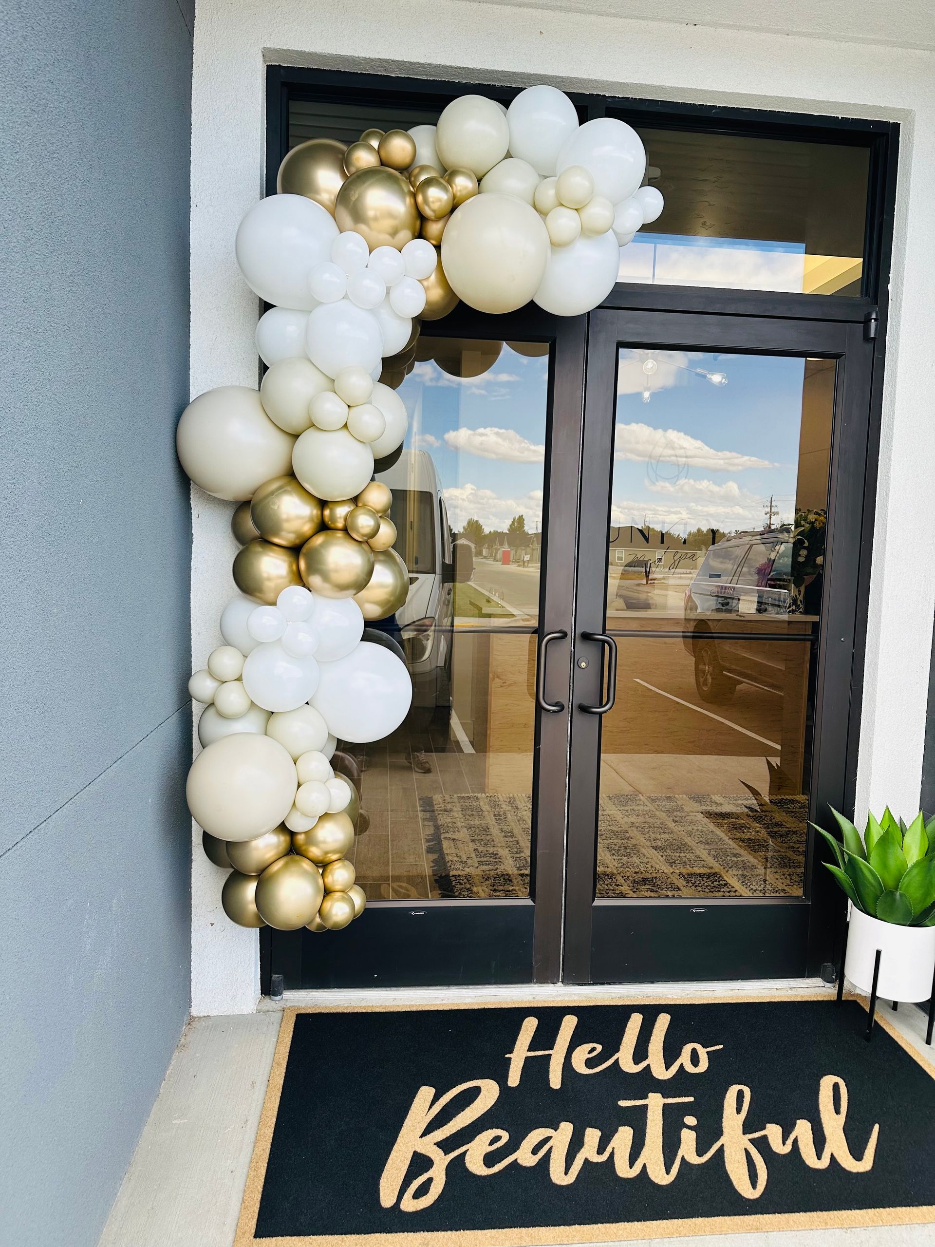 A door with balloons and a welcome mat that says hello beautiful