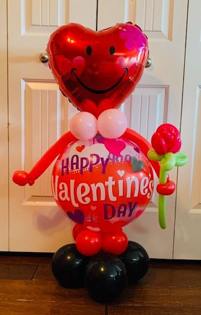 A valentine 's day balloon shaped like a person holding a rose