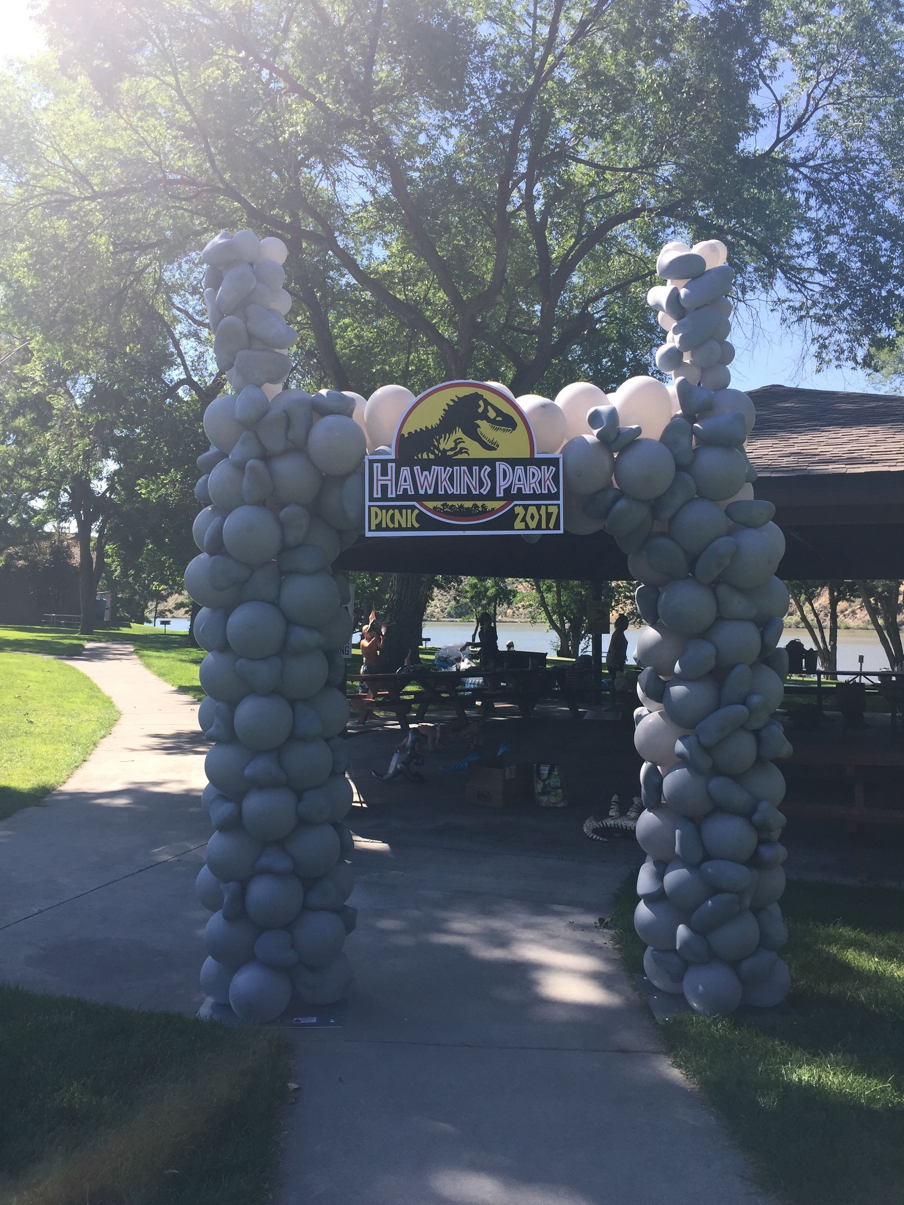 A large arch made of balloons in the shape of a dinosaur park.