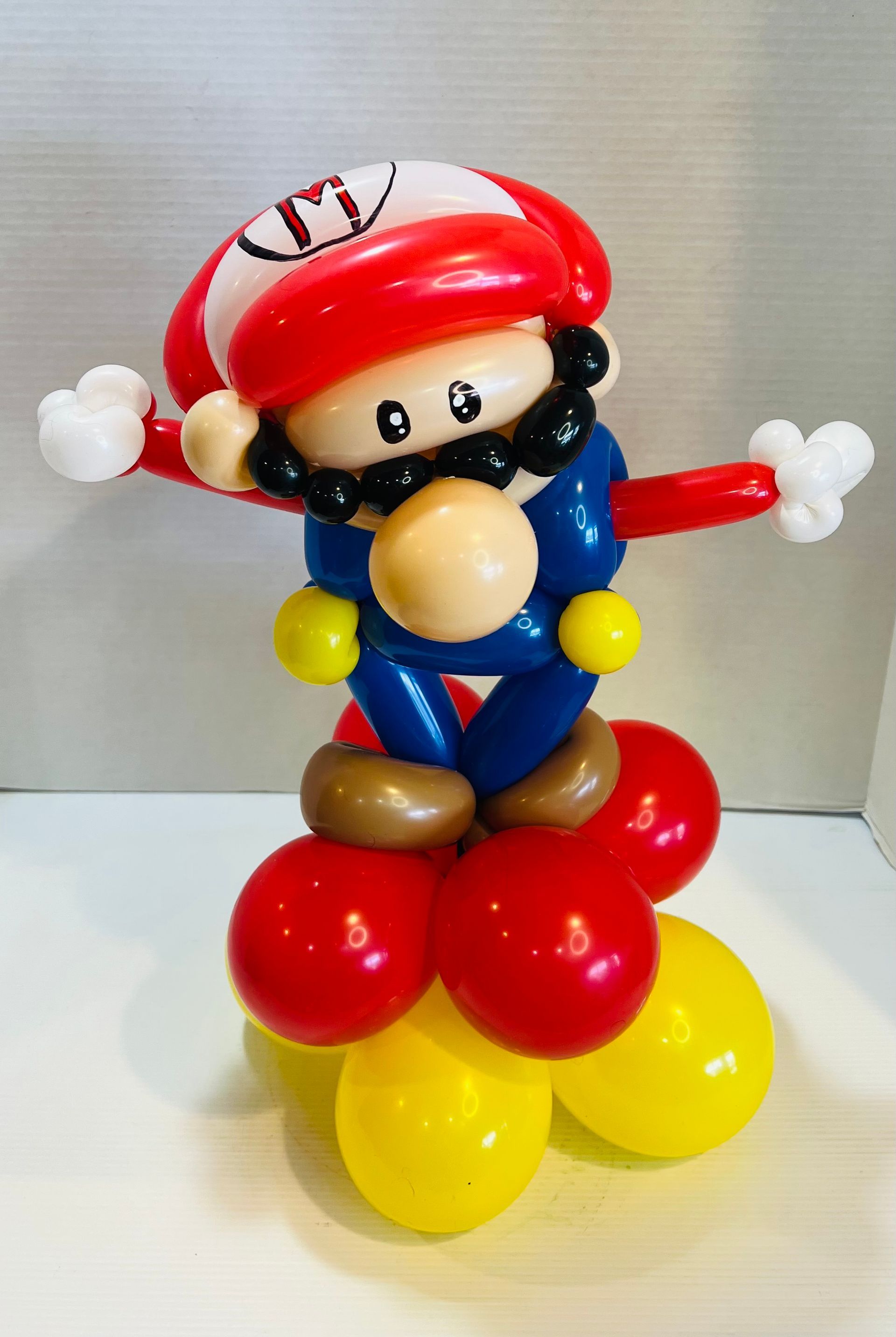A mario made out of balloons is sitting on a table