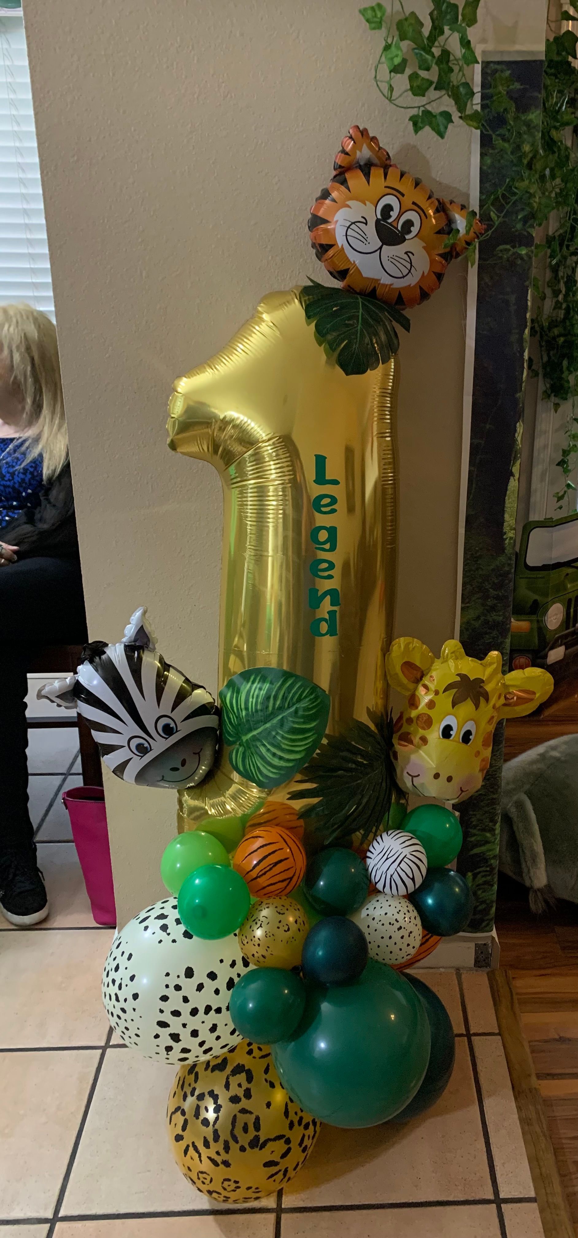 A bunch of balloons are sitting on a tiled floor in a room.